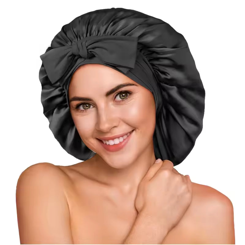 A smiling woman wearing a black silk bonnet with a bow in front.